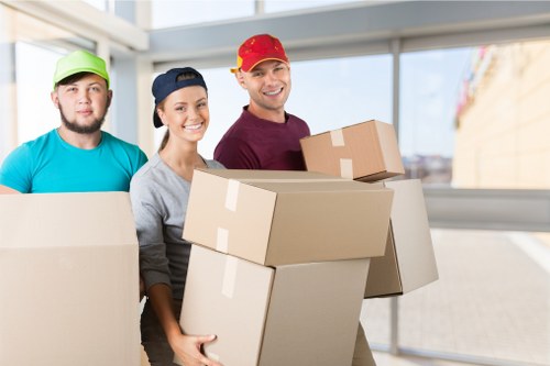Movers carrying boxed household items in a Lambeth apartment block